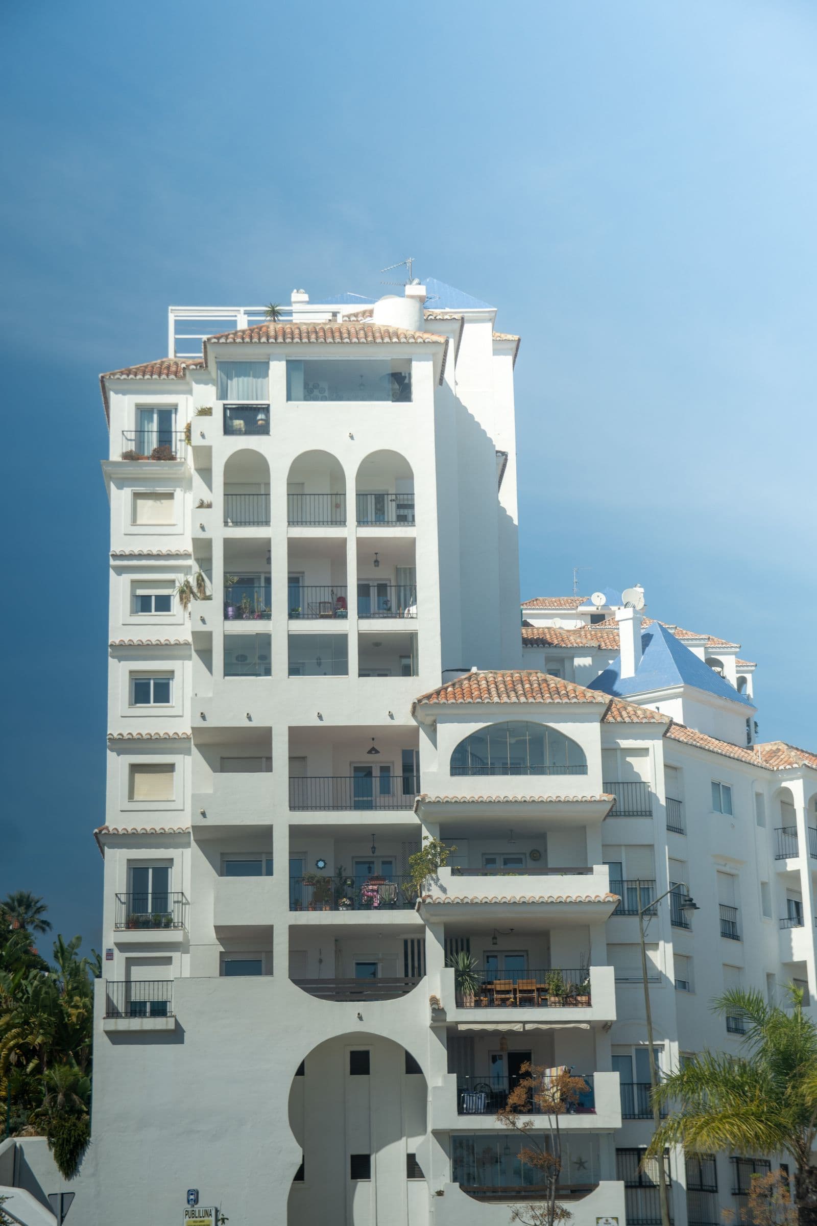 Exterior of a multi-storey Mediterranean apartment building with balconies